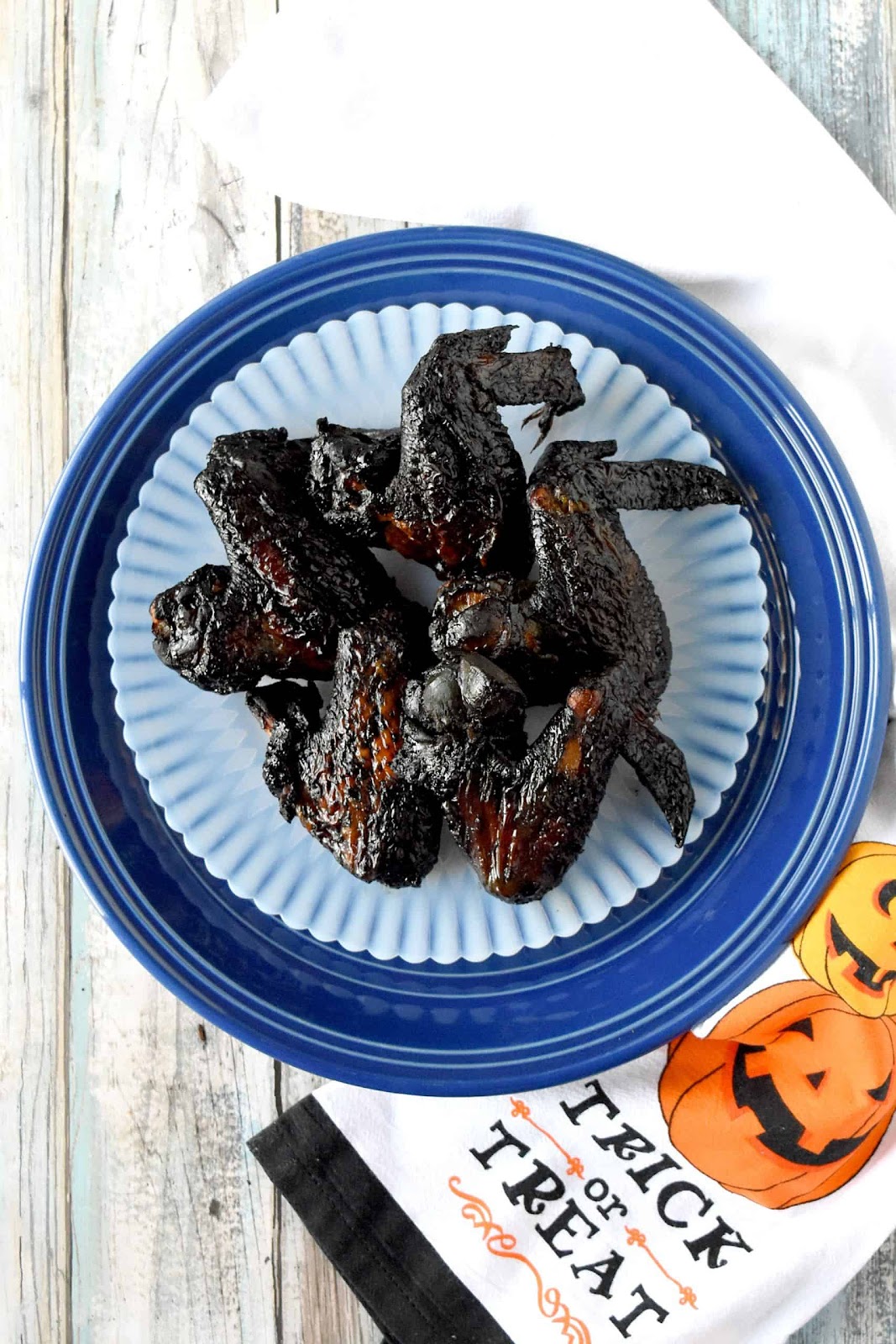 Bat wings -savory healthy Halloween treats - shown on a white plate.