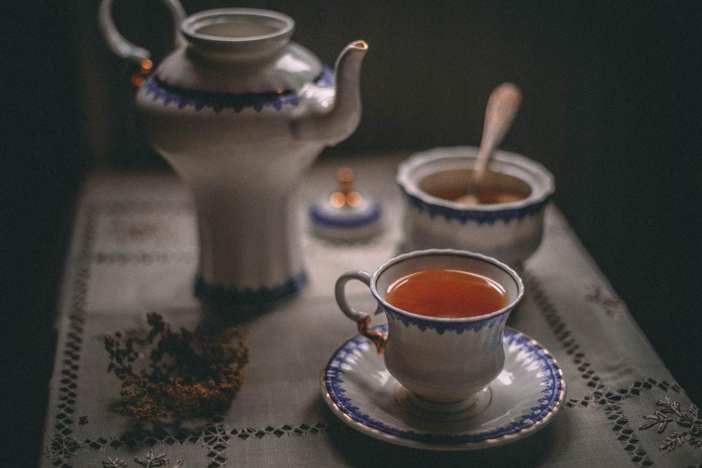 white ceramic teapot beside white ceramic teacup on saucer