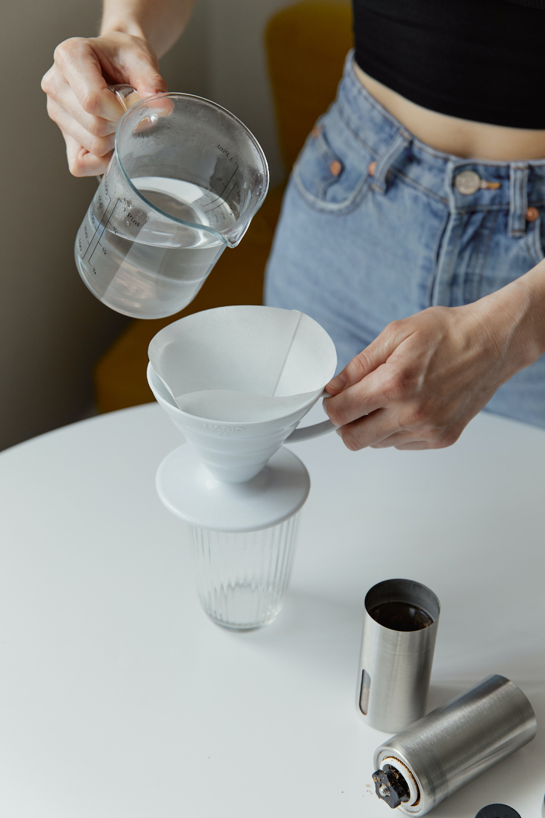barista pouring water on white ceramic cup with filter
