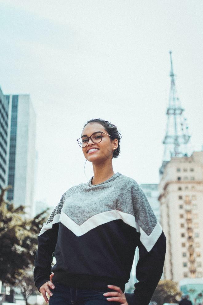 A person smiling in front of a tower
Description automatically generated