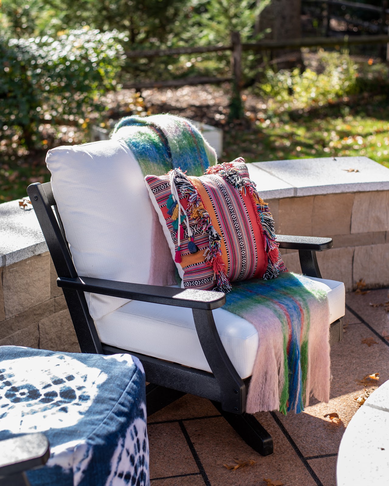 This Polywood chair sitting atop a Carolina Coral granite patio is made of recycled materials, such as milk jugs and products that are oceanbound and are able to sustain all weather conditions just like the stone. The versatile pillow and pouf from SmithHönig can be used both outdoors and indoors.