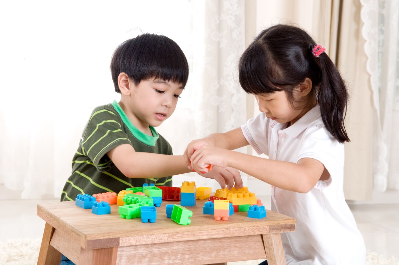 Crianças brincando e compartilhando blocos de montar 