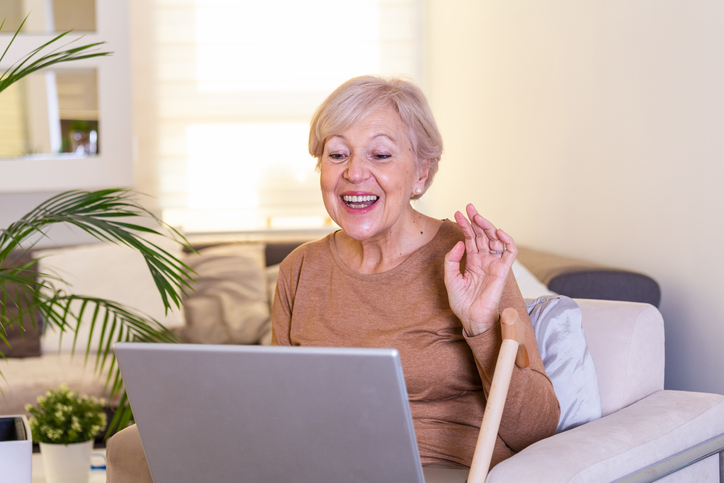 senior woman smiles and chats at her computer