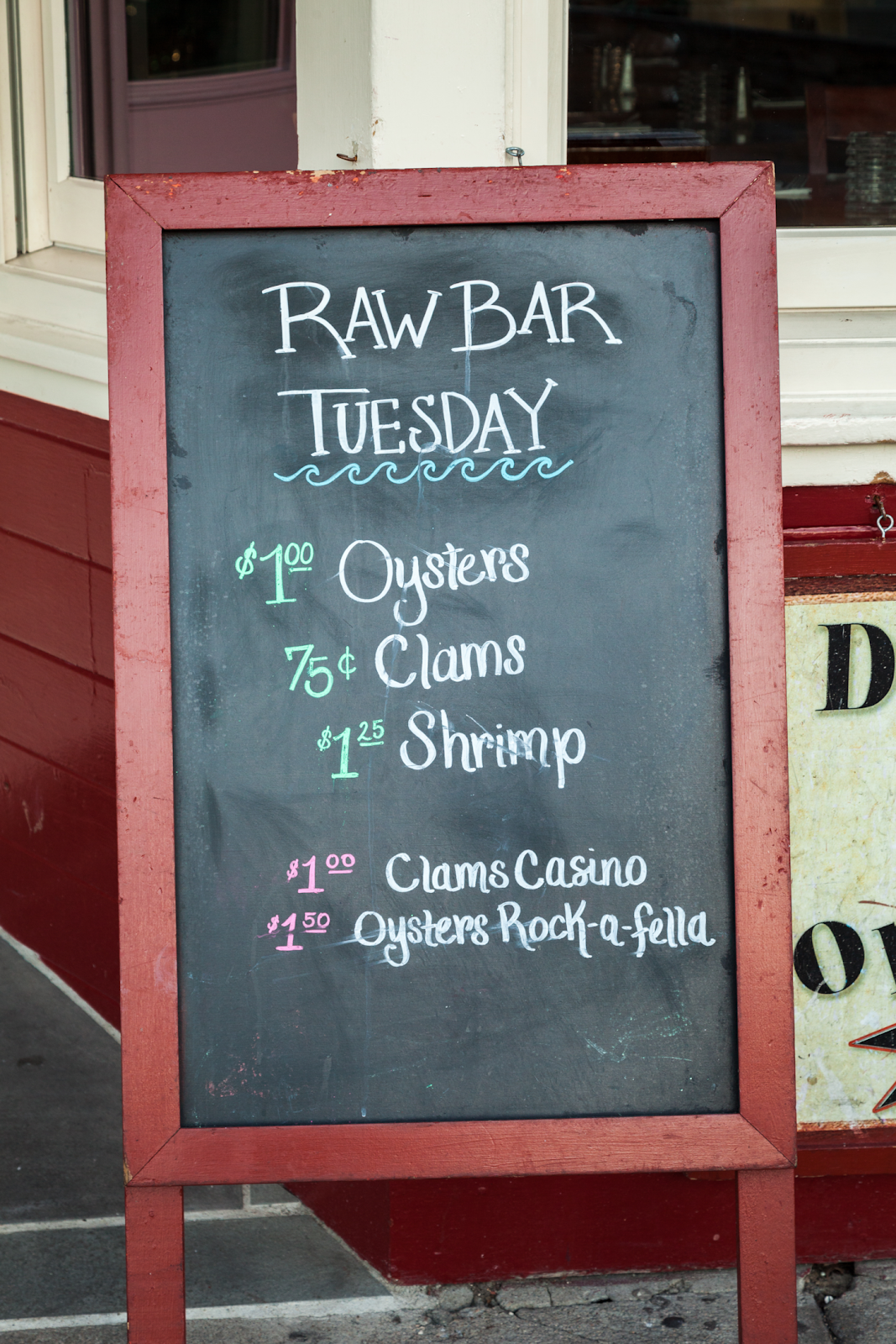 A sandwich board with the Tuesday specials at a restaurant