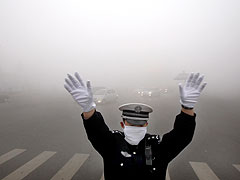 A police officer works on a street blanketed in heavy smog in Harbin on October 21, 2013.