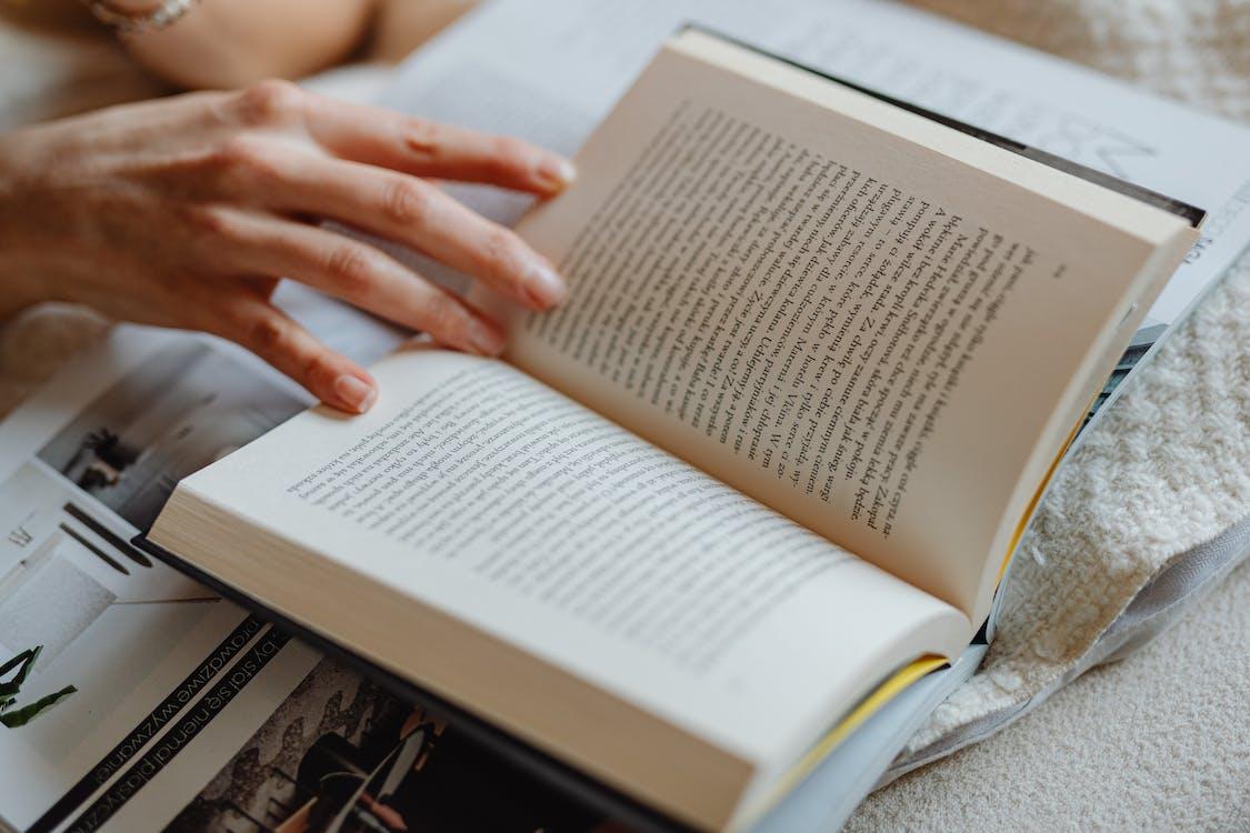 Free Person Holding The Pages Of An Open Book Stock Photo