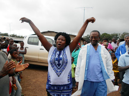 Ebola survivor, accompanied by medical director, being welcomed by her community - Firestone District, Liberia, 2014