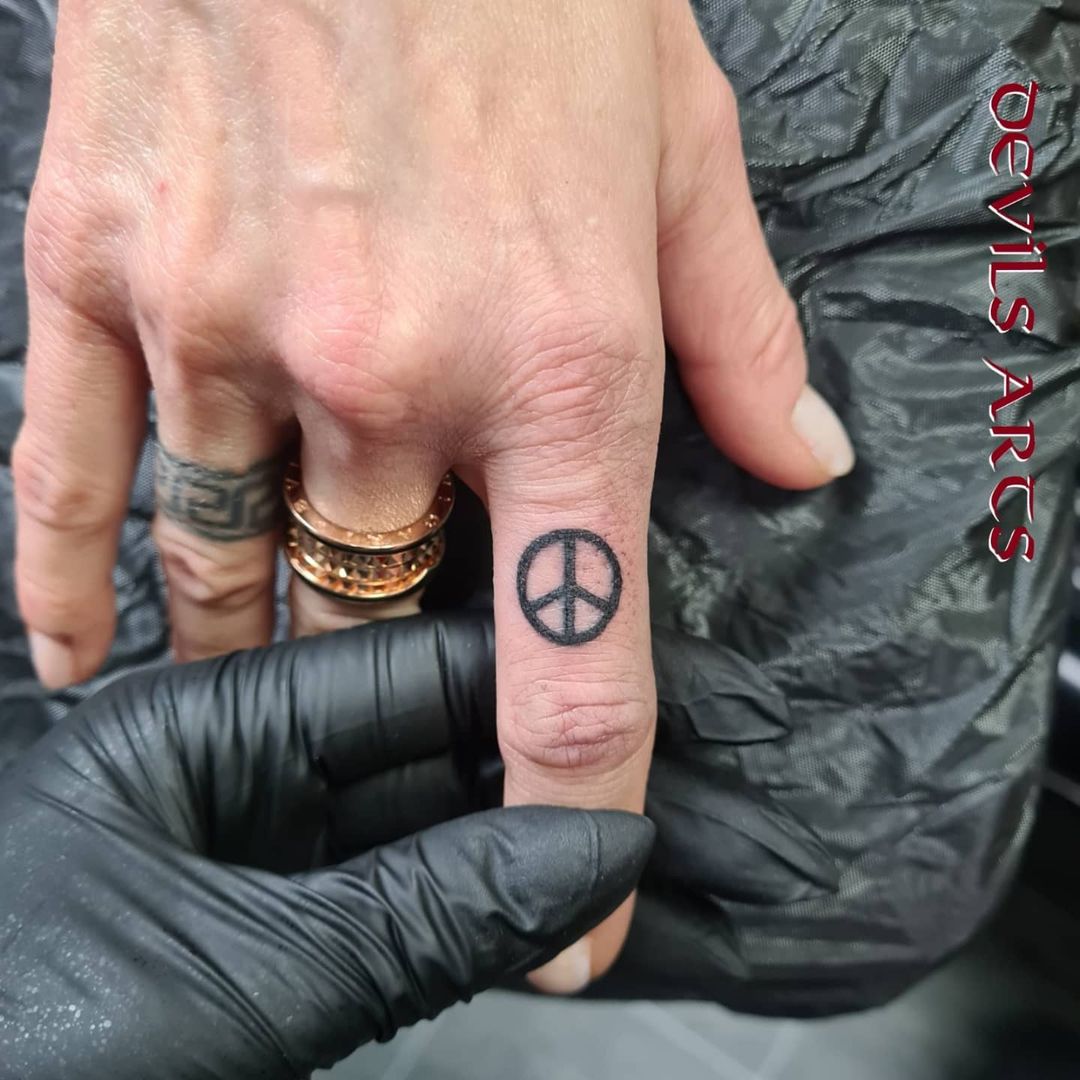 Tiny Peace Tattoo On Finger