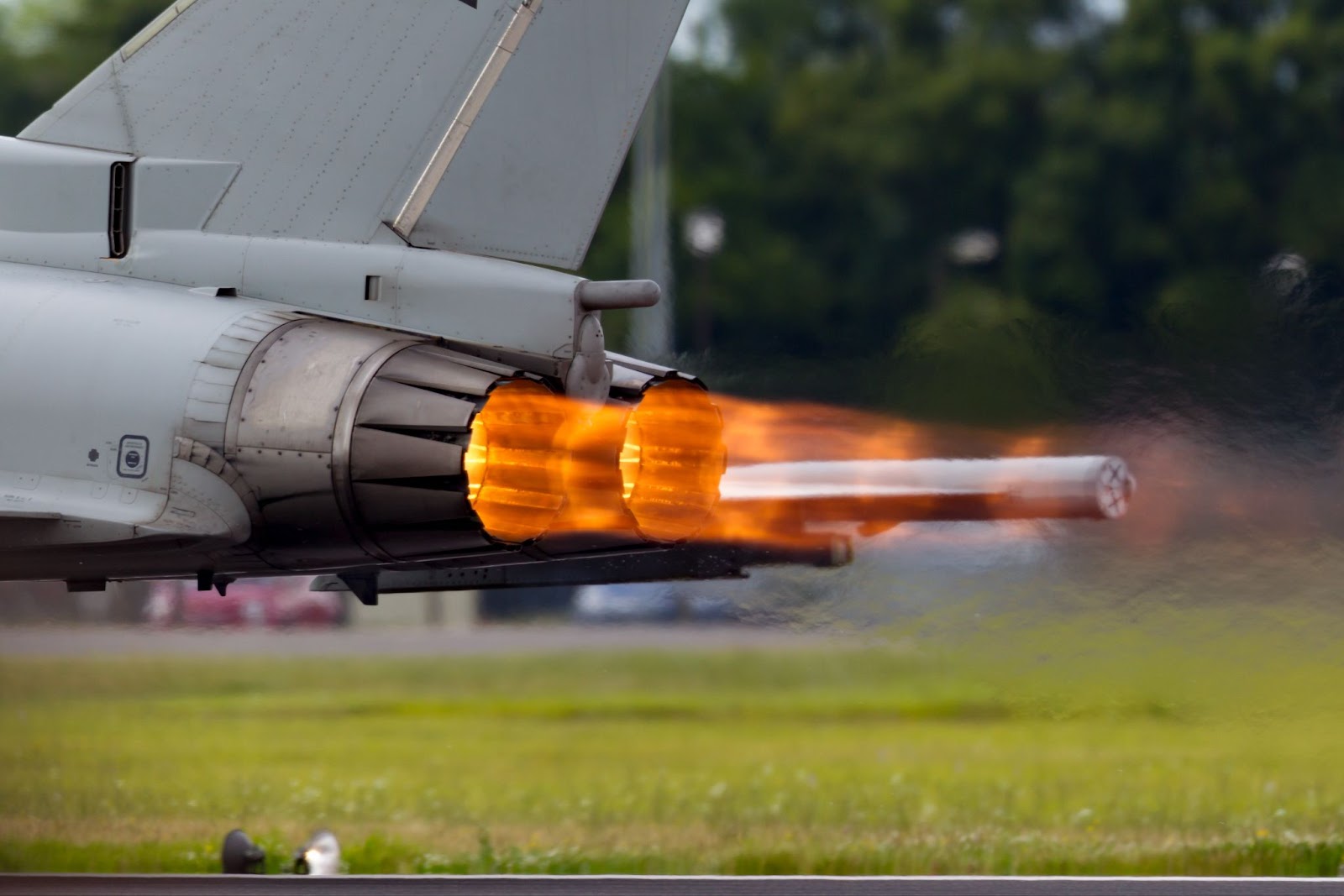 A fighter jet with its afterburner activated.
