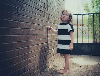 little girl wearing a striped crochet toddler dress