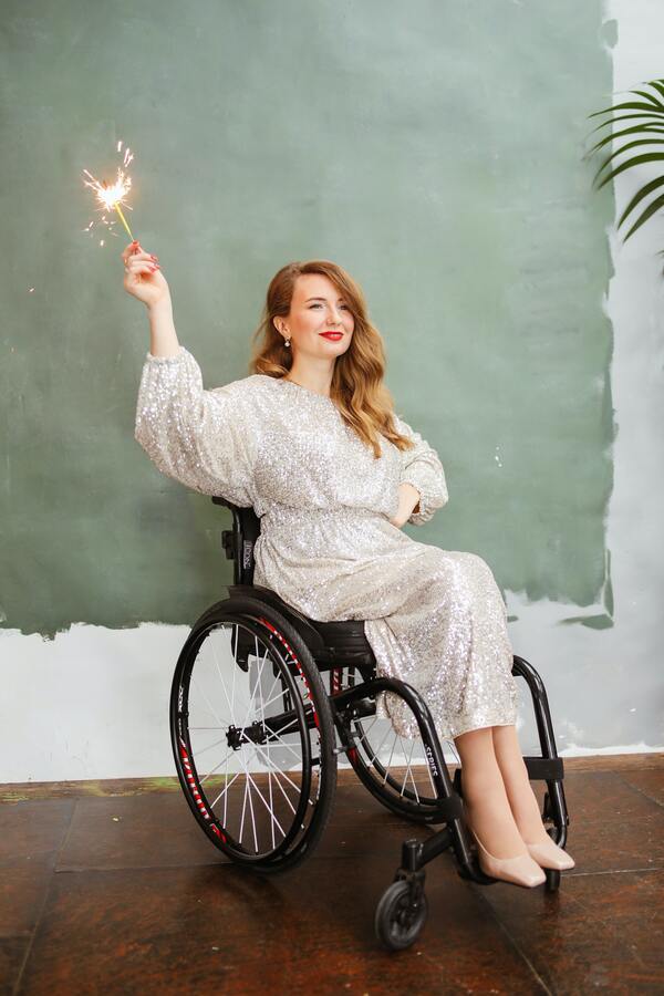 foto de uma mulher loira cadeirante segurando uma vela 