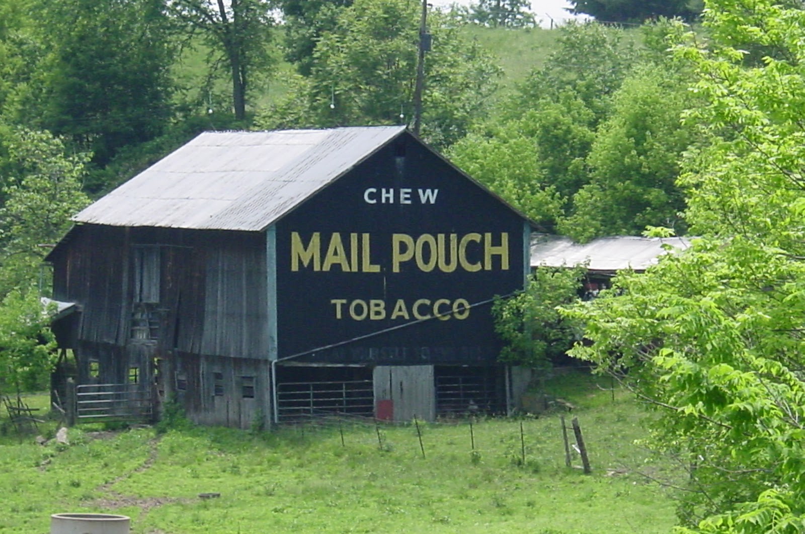 An old barn with Chew Mail Pouch Tobacco, painted in yellow on a black background. 