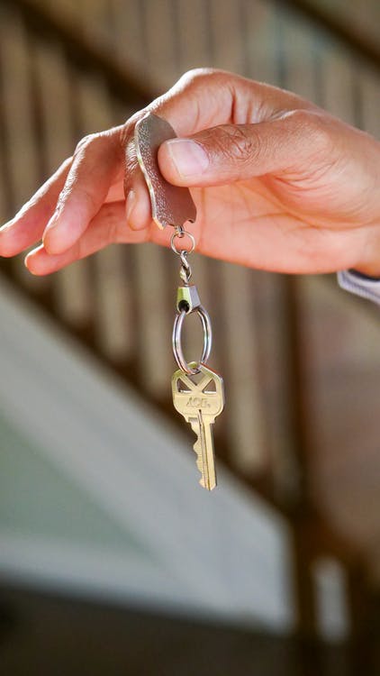Free Person Holding a Keychain with Key Stock Photo