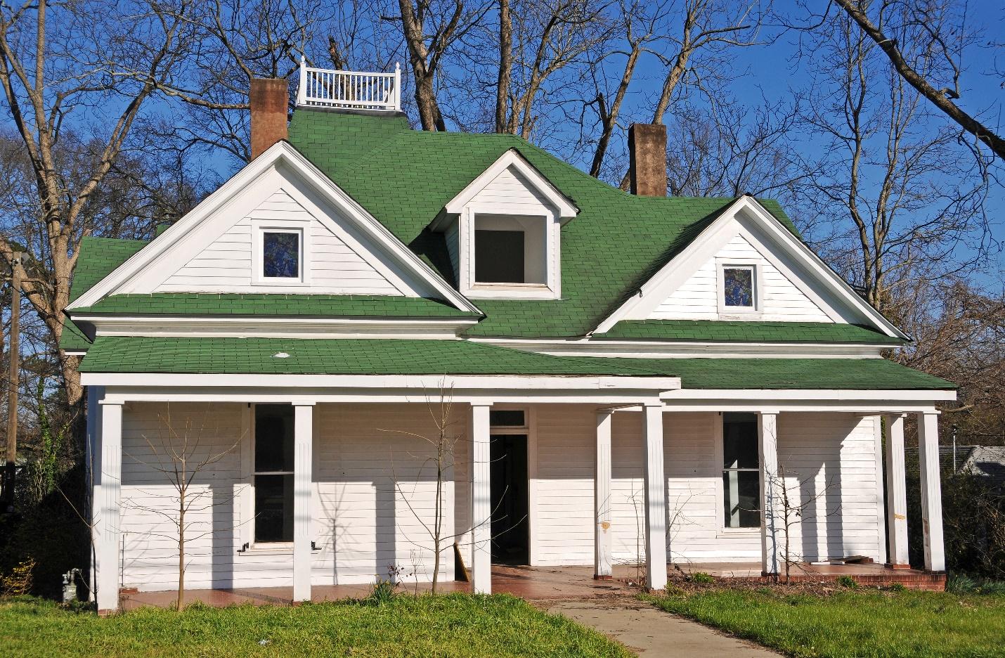 A white house with a green roof

Description automatically generated with low confidence