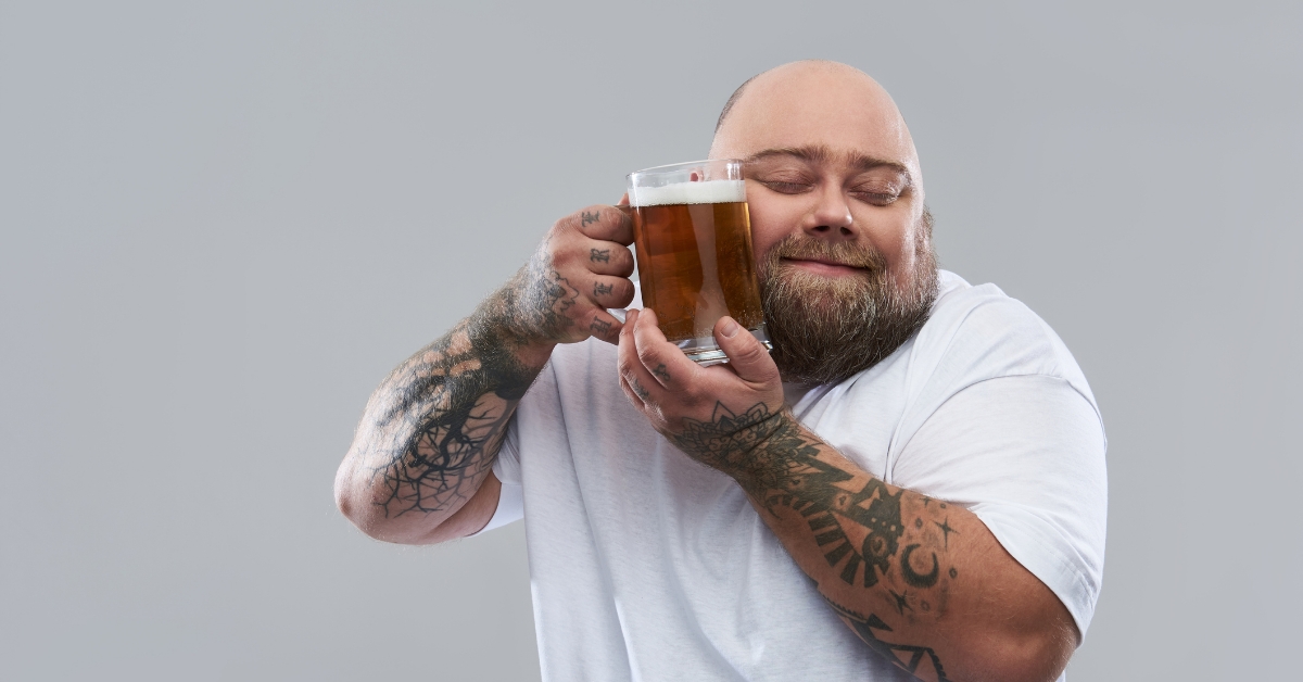 tattooed man with a beer to his face