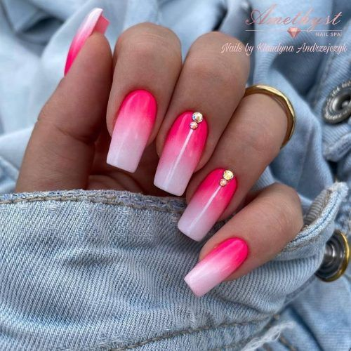 Full picture of gorgeous hands showing off pink ombre nails with accessories