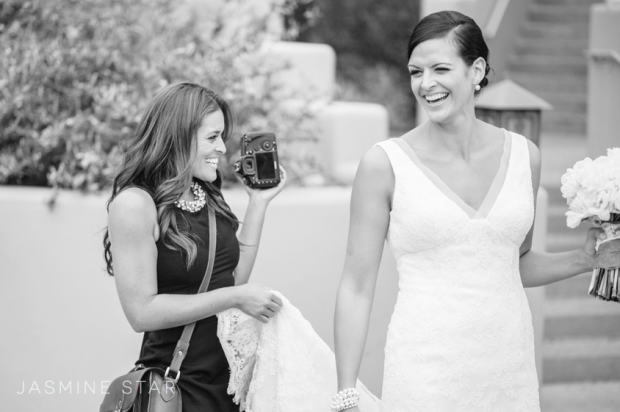 A photographer holding a bride’s dress