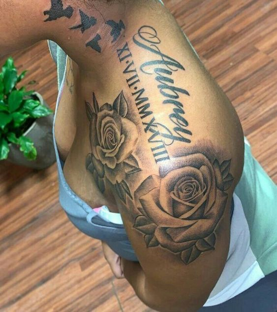 lady with a flower and text shoulder tattoo