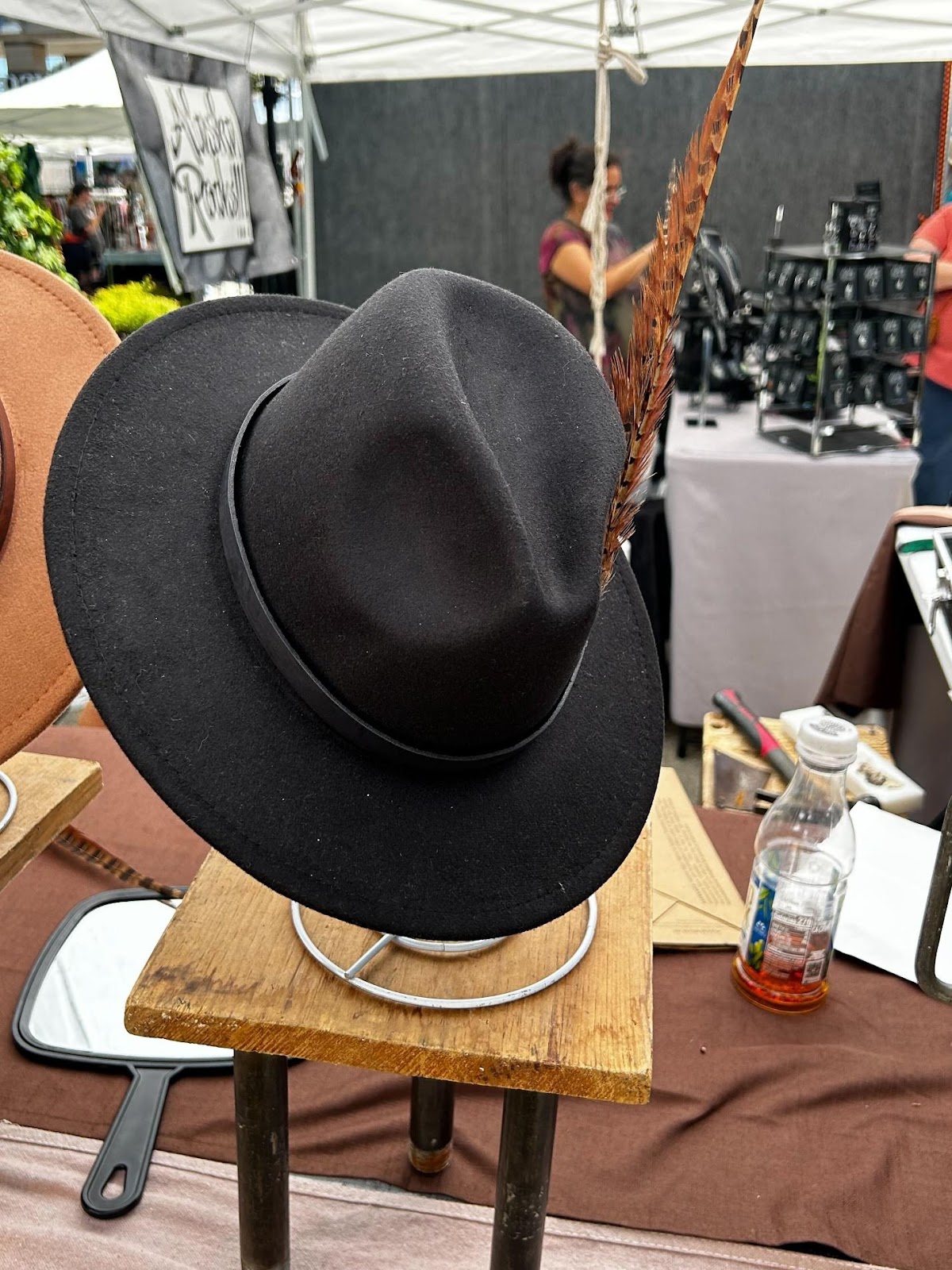A black hat on a stand

Description automatically generated