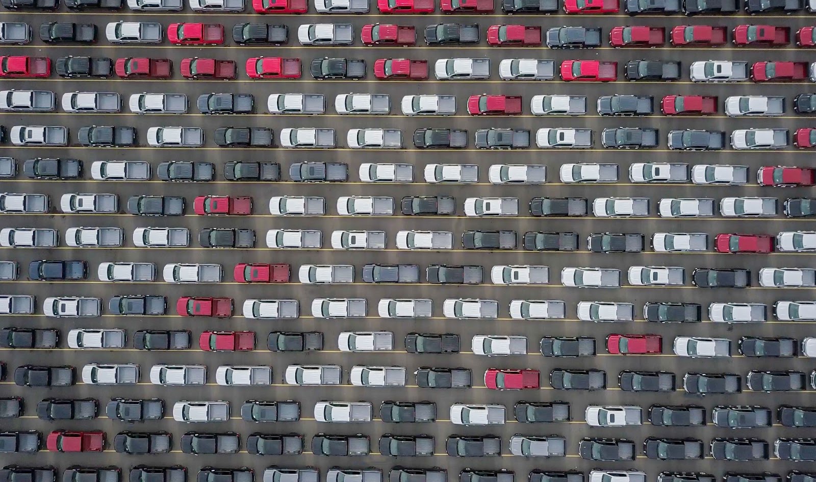 An aerial view of new red, white, and black vehicles 