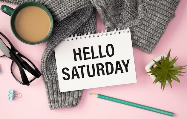 'Hello Saturday' Printed on Calendar With Personal Items in the Background.