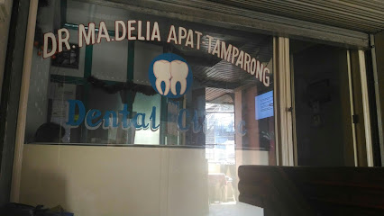 Glass door of Dr. Ma. Delia Apat Tamparong Dental Clinic with tooth graphics; trusted dentist in Iligan.