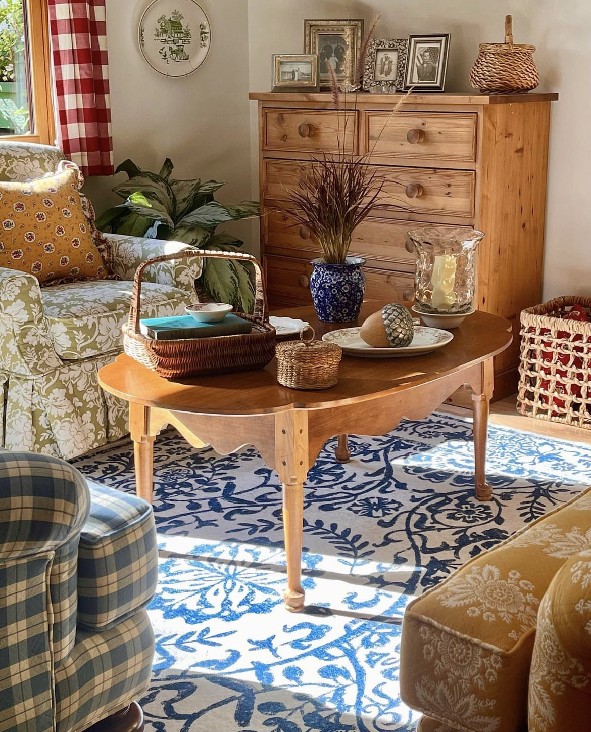 This cottage living room is a charming and cozy space, with large windows that let in plenty of natural light. The walls are painted in a soft cream color, which creates a warm and welcoming ambiance.There are two upholstered chairs that provide comfortable seating. The chairs are covered in a soft fabric and feature plush cushions, making them the perfect spot to curl up with a good book or enjoy a cup of tea. A small wooden side table sits between the chairs, offering a convenient spot to rest a drink or book.Against one wall, there is a tall dresser made of wood adding to the rustic charm of the room. It features several drawers, providing plenty of storage space for books, games, or other items.