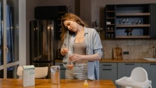 a-women-talking-on-her-mobile-phone-and-making-breakfast-simultaneously