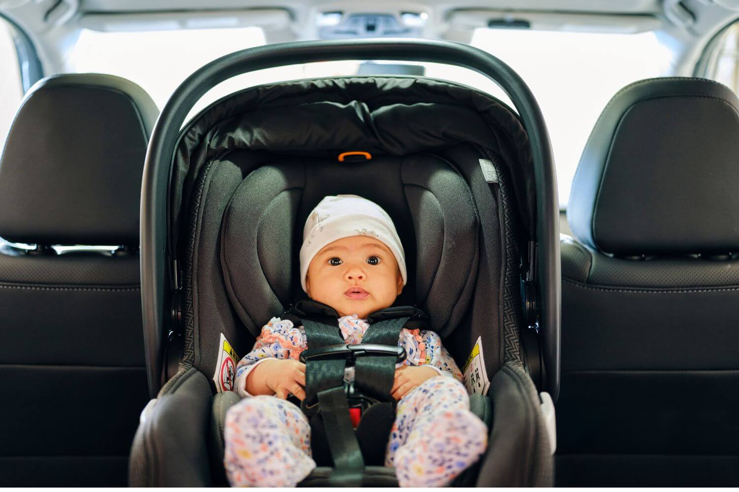 A newborn baby in a car seat