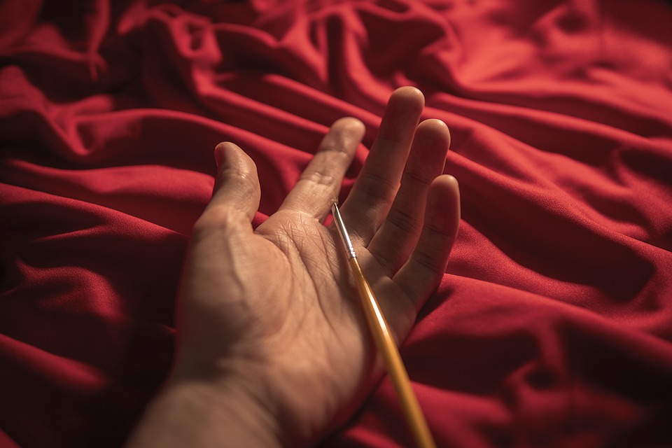 Hand holding a paint brush 