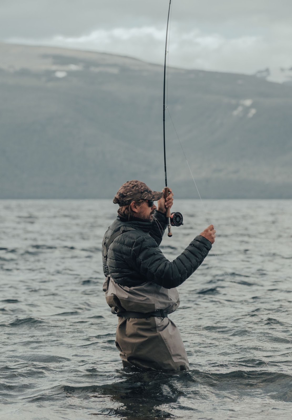 a man with waders on fly fishing