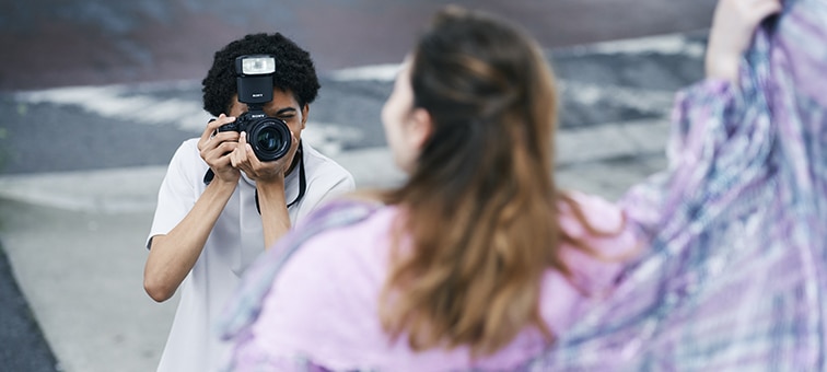 A man taking a portrait outdoors with high-speed continuous flash