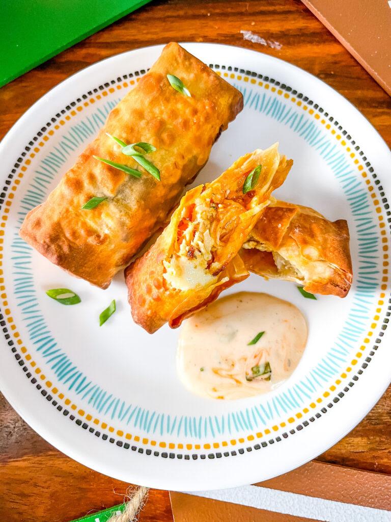 Buffalo Chicken Egg Rolls on a plate with one cut open