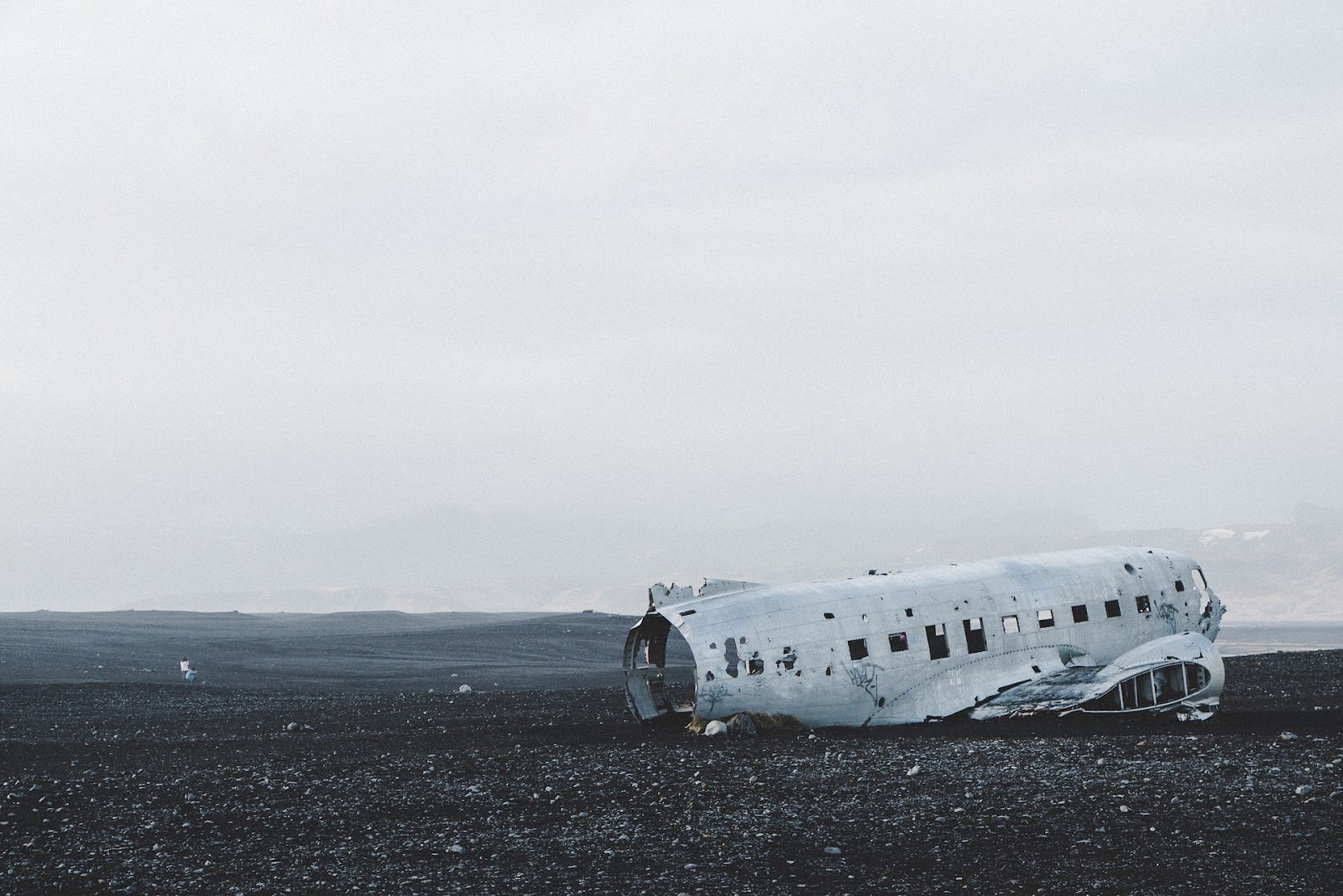 dc-3 plane wreck tourist attraction on black pebble beach seen on a misty day in iceland