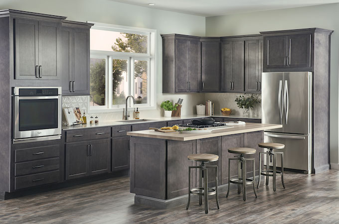 Clean Your finished wood. Gray cabinets with stainless steel appliances. Island with three stools. 