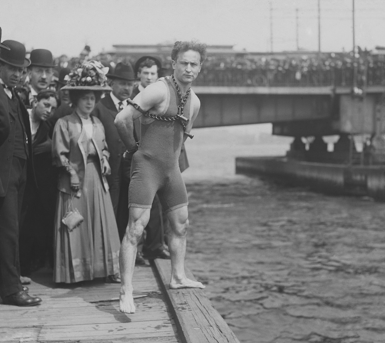 Houdini stands chained before a crowd of spectators in Boston
