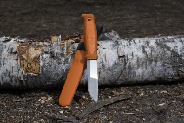 Fixed blade tactical knife with orange handle and plastic sheath
