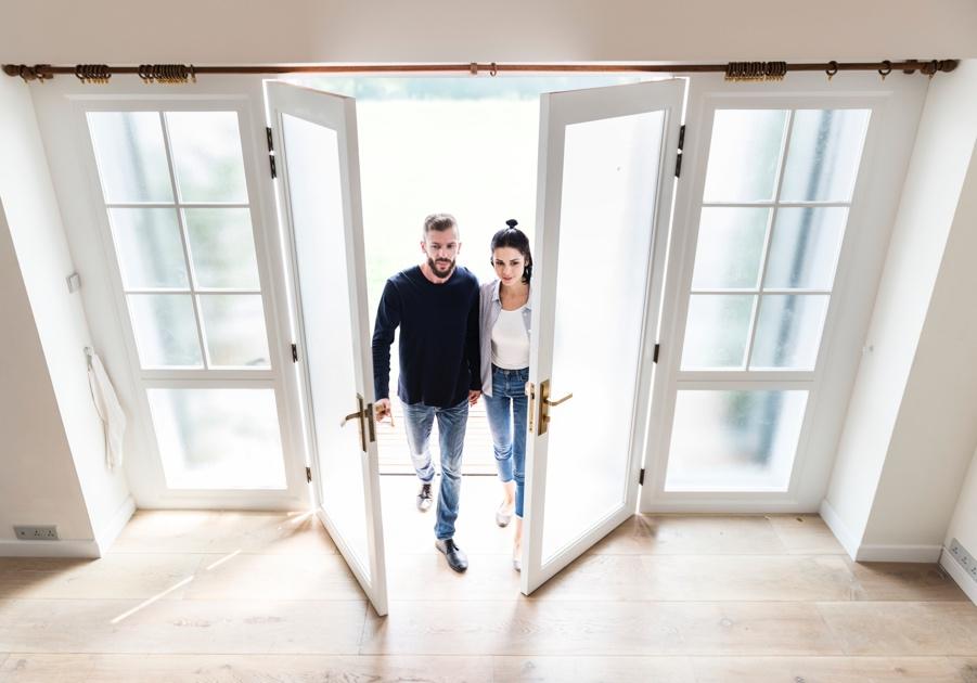 Two people standing in a room with white doors

Description automatically generated with medium confidence