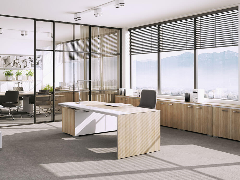 A meeting area separate from an office by a glass partition.