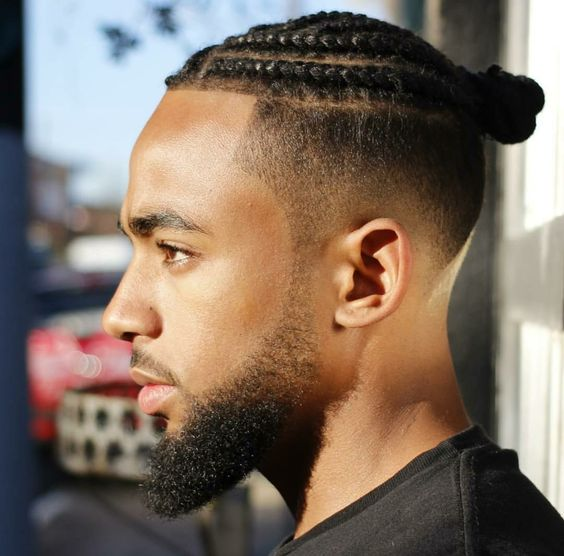 a guy wearing a fade haircut and cornrow braid hairstyles for men
