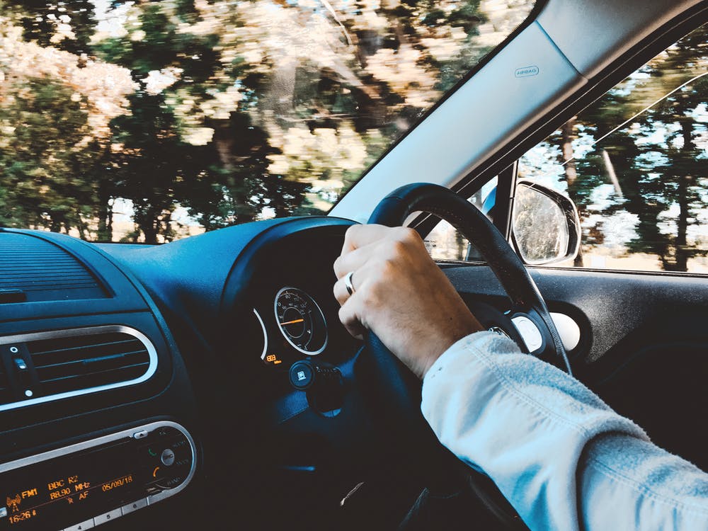 Person Holding Black Vehicle Steering Wheel