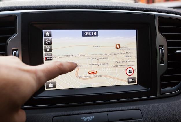 Navigation panel inside a car. finger pointing on destination point.