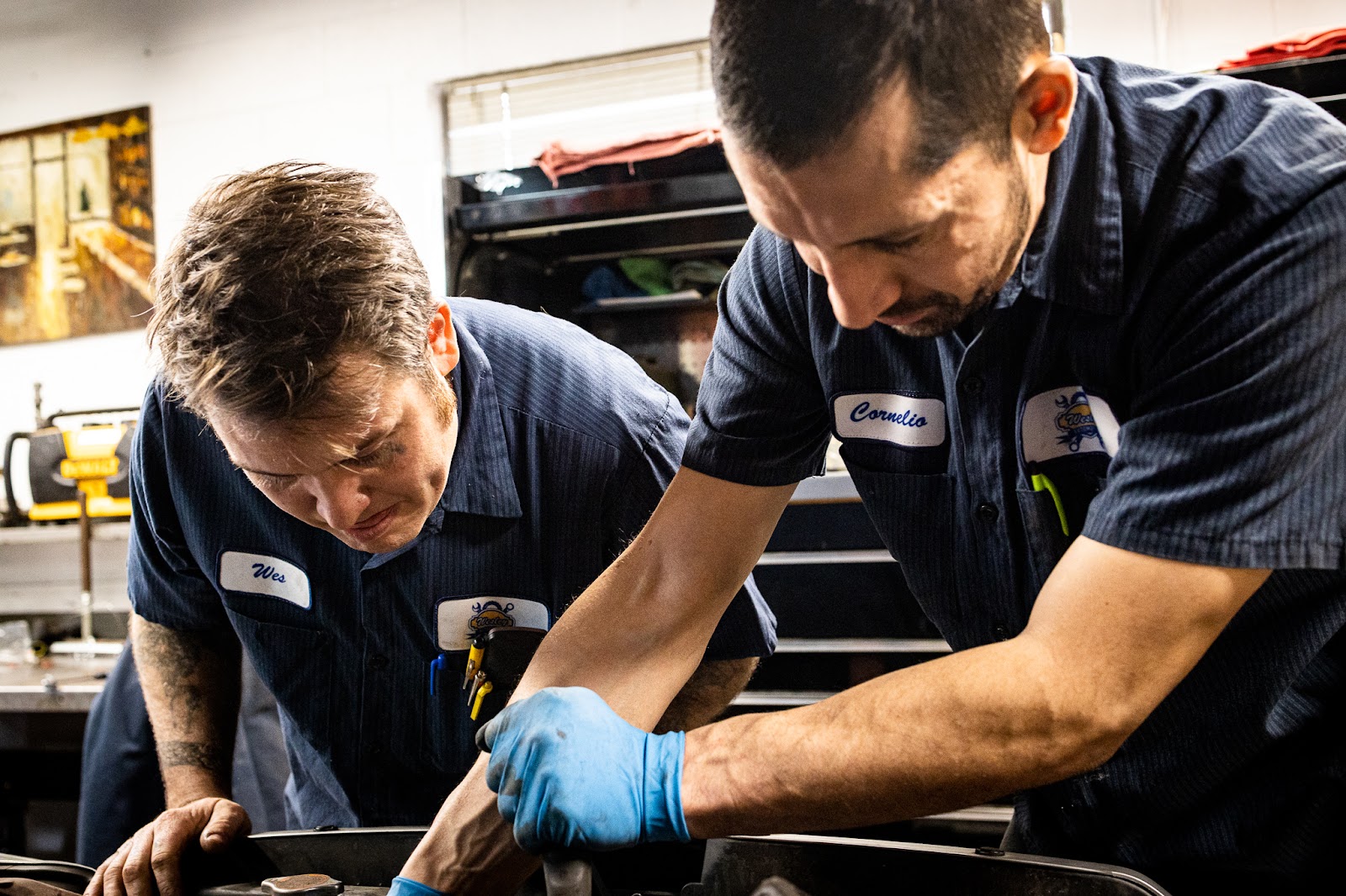 Wesley Automotive repair team  diagnosing a car problem in engine compartment 