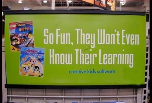 A green sign advertising creative kids software, which reads: "So Fun, They Won't Even Know Their Learning". This uses the wrong form of "their" - it should be "they're". 
