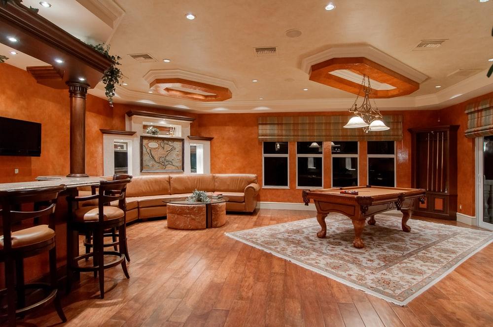 billiard table in center of brown painted room