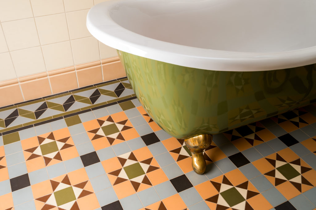 colorful types of floor tiles made of cement next to an old tub