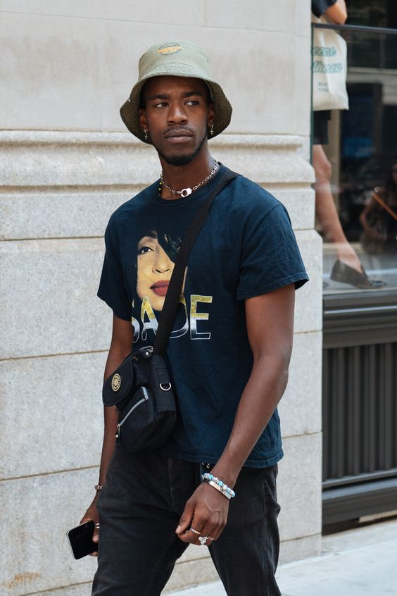A man wearing a t-shirt and pants and a bucket hat