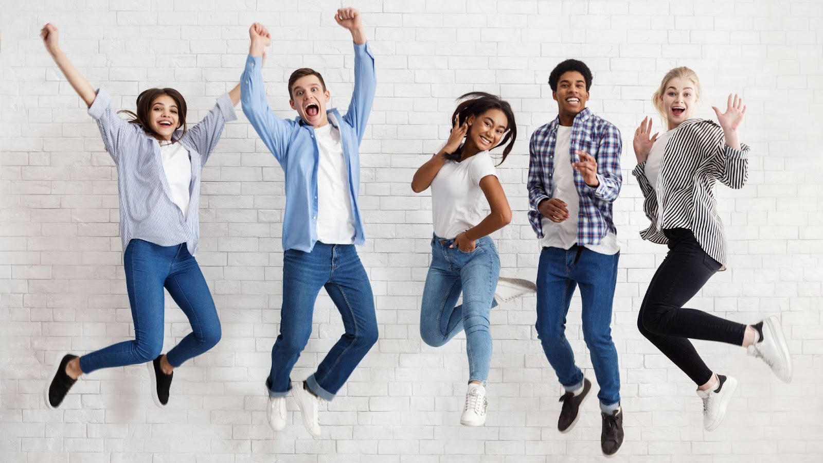 Five young people happily jumping in the air