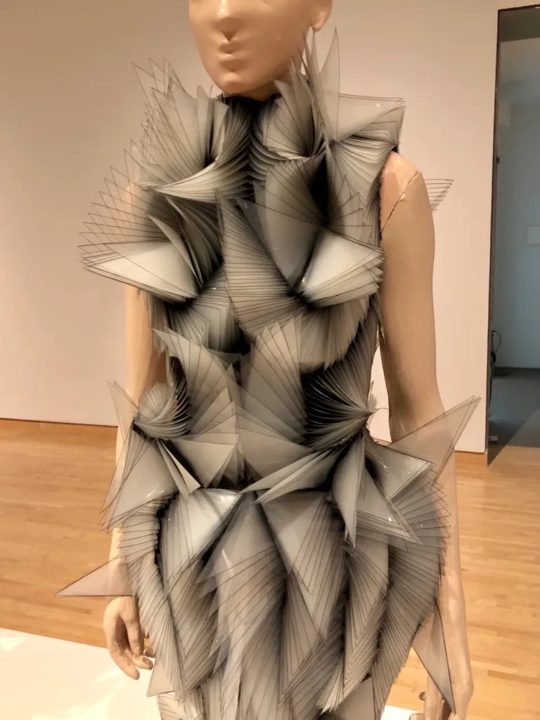 A mannequin wearing a dress made of paper

Description automatically generated