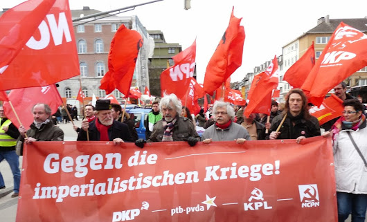 Demonstranten mit KP-Fahnen und Transparent: »Gegen die imperialistischen Kriege! DKP - ptb-pvda - KPL - NCPN«.